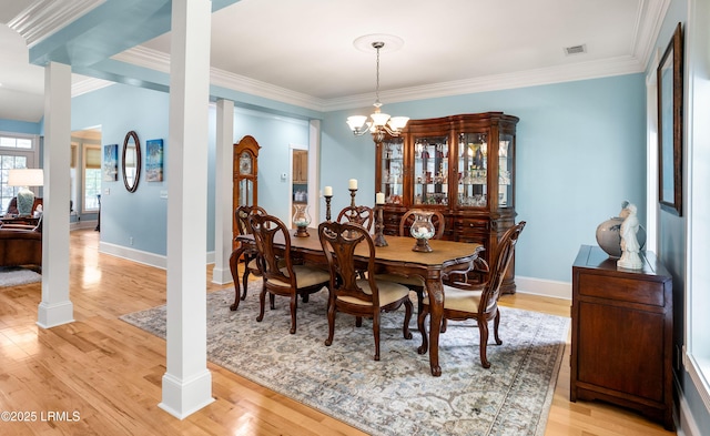 dining area with light wood finished floors, visible vents, ornamental molding, and decorative columns