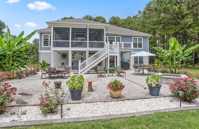 back of house featuring stairway, outdoor dining area, a patio area, and a sunroom