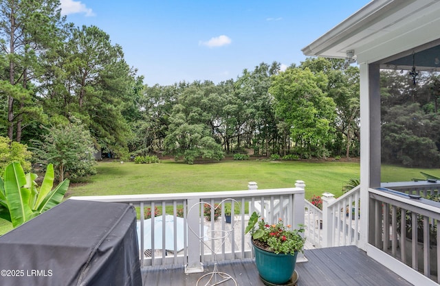 wooden terrace featuring a lawn