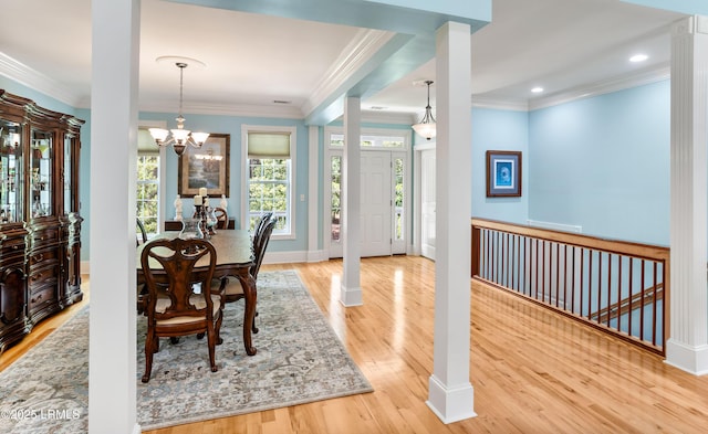 dining space featuring a chandelier, baseboards, wood finished floors, and ornamental molding