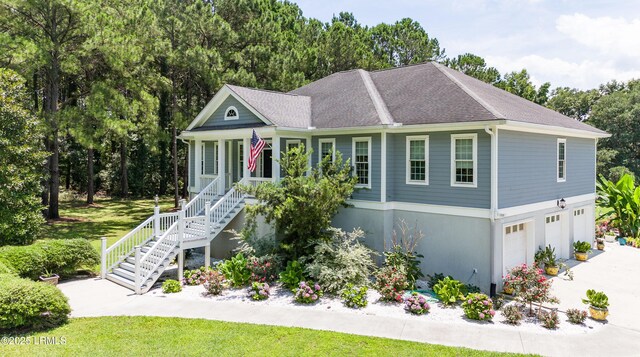 view of front of house with a garage, stairs, and a shingled roof