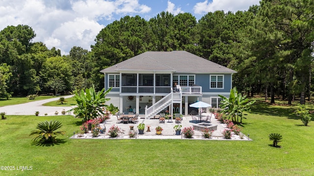 rear view of property with outdoor dining area, a yard, a sunroom, stairs, and a patio area