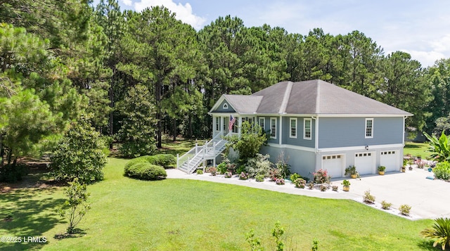 view of front of house with a garage, driveway, a front yard, and stairway