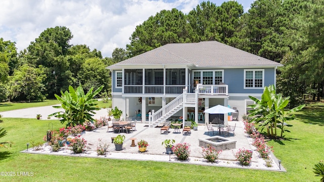 back of property with a yard, stairway, a patio, and a sunroom