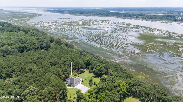 drone / aerial view featuring a wooded view and a water view