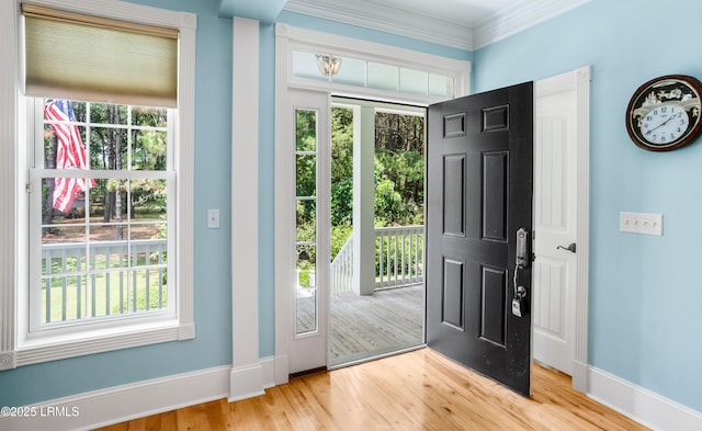 doorway with ornamental molding, baseboards, and wood finished floors