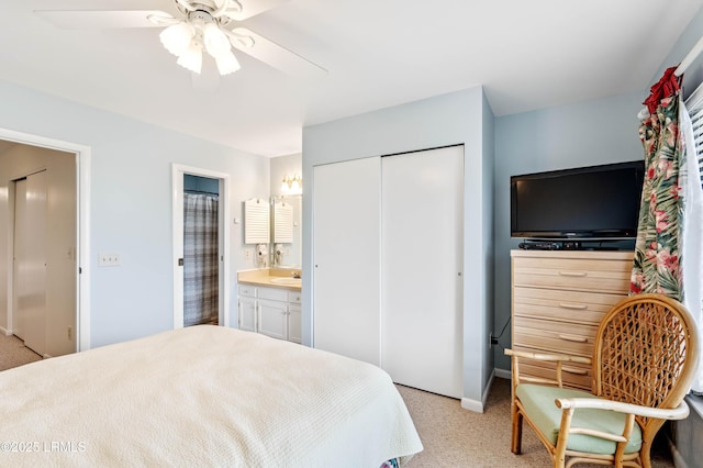 bedroom with light carpet, a closet, a sink, and connected bathroom