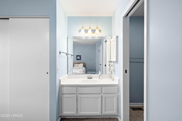 bathroom with ensuite bath, vanity, tile patterned flooring, and baseboards