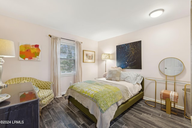 bedroom featuring baseboards and wood finish floors