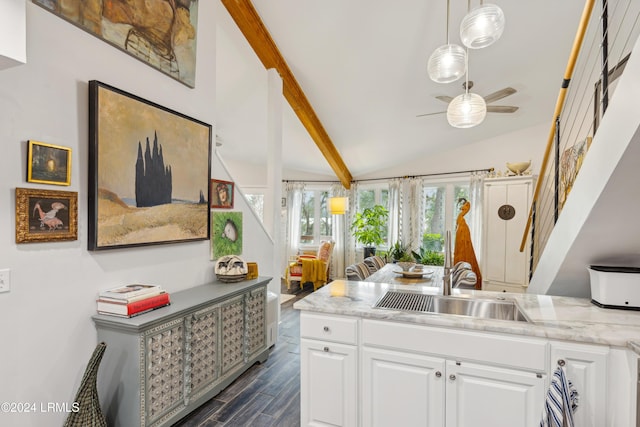 kitchen featuring vaulted ceiling with beams, ceiling fan, dark wood finished floors, white cabinetry, and a sink