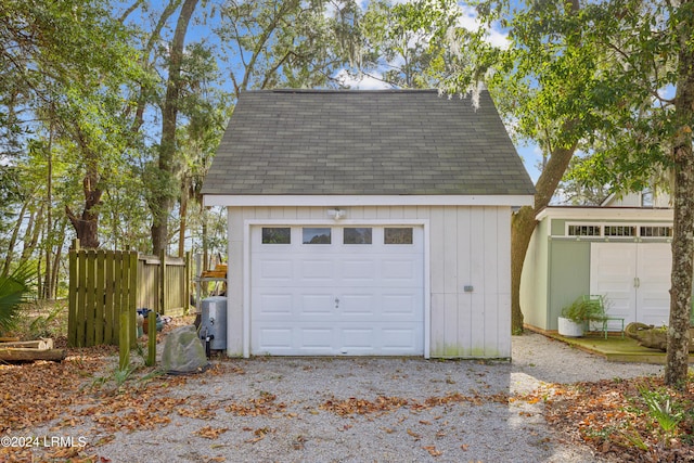 detached garage with fence and water heater