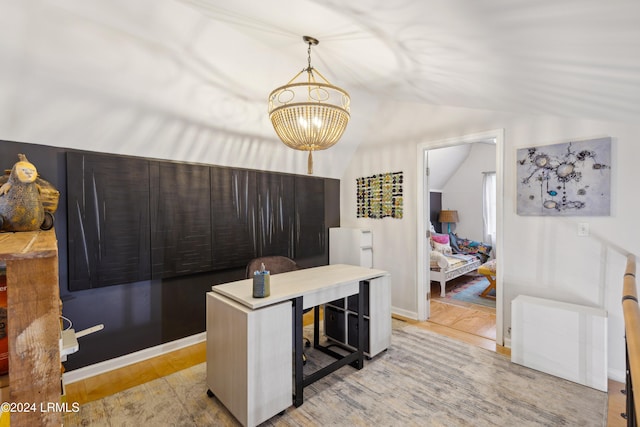 office space featuring light wood-type flooring, a chandelier, and vaulted ceiling