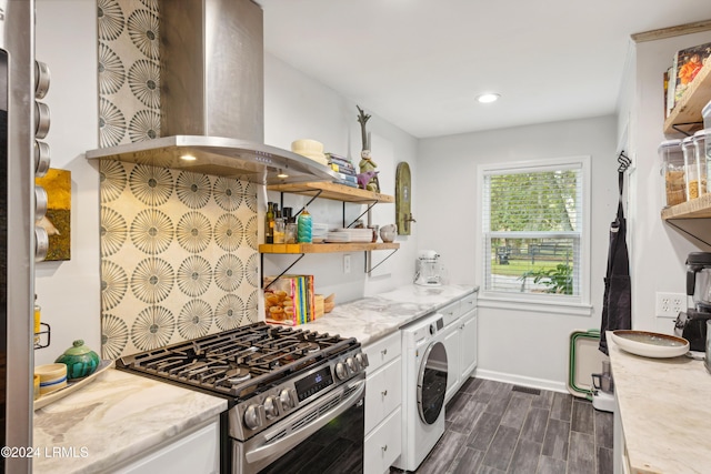 kitchen featuring wood finish floors, stainless steel range with gas cooktop, white cabinets, extractor fan, and washer / dryer