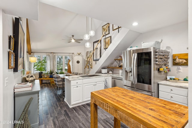 kitchen with a peninsula, dark wood-style flooring, a sink, appliances with stainless steel finishes, and white cabinetry