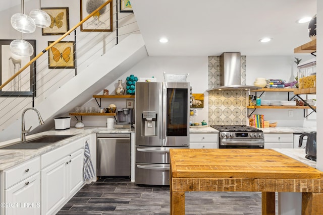 kitchen with open shelves, appliances with stainless steel finishes, white cabinetry, wall chimney exhaust hood, and a sink