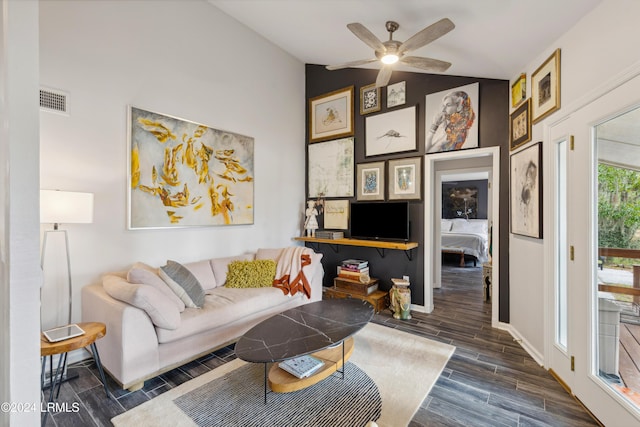 living room featuring visible vents, baseboards, wood finish floors, lofted ceiling, and a ceiling fan