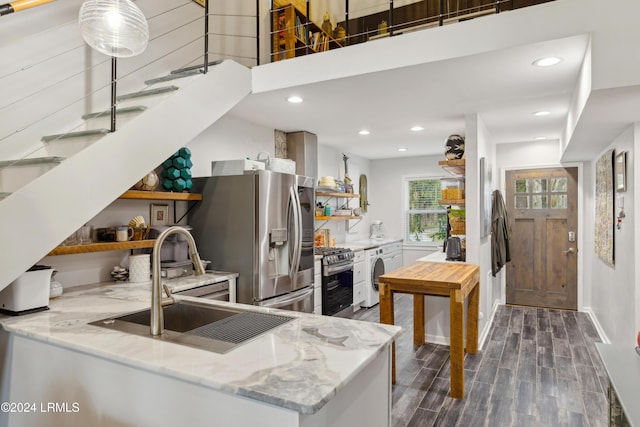 kitchen with open shelves, dark wood finished floors, stainless steel appliances, washer / clothes dryer, and a sink