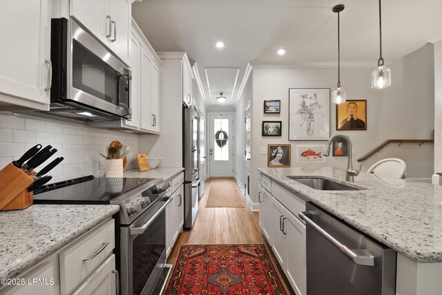 17 Marlowe Way Unit 1, Bluffton, SC 29910 - kitchen with stainless steel appliances, a sink, white cabinetry, light wood-style flooring, and crown molding