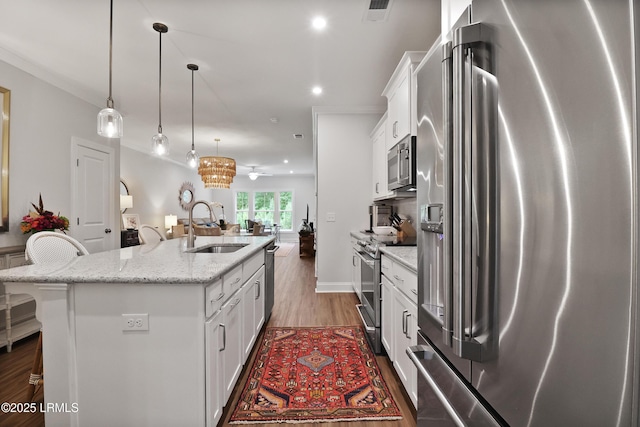 17 Marlowe Way Unit 1, Bluffton, SC 29910 - kitchen with appliances with stainless steel finishes, a sink, wood finished floors, open floor plan, and white cabinets