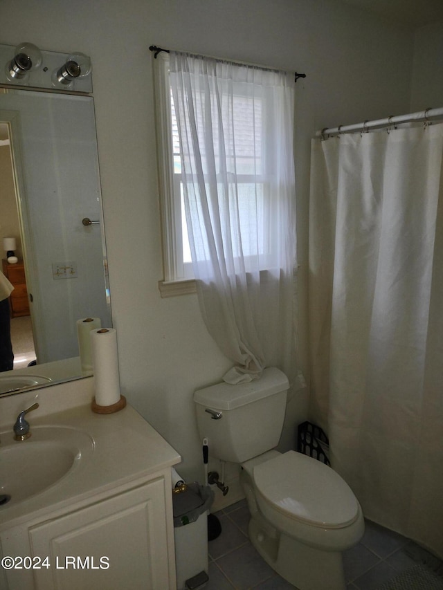 bathroom featuring tile patterned flooring, vanity, walk in shower, and toilet