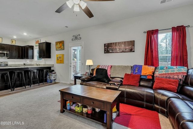 carpeted living room featuring ceiling fan