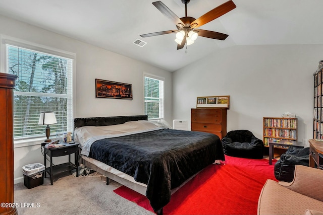 bedroom featuring multiple windows, vaulted ceiling, carpet floors, and ceiling fan