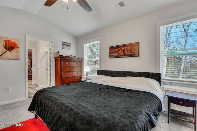 bedroom featuring ensuite bathroom, lofted ceiling, light carpet, and ceiling fan