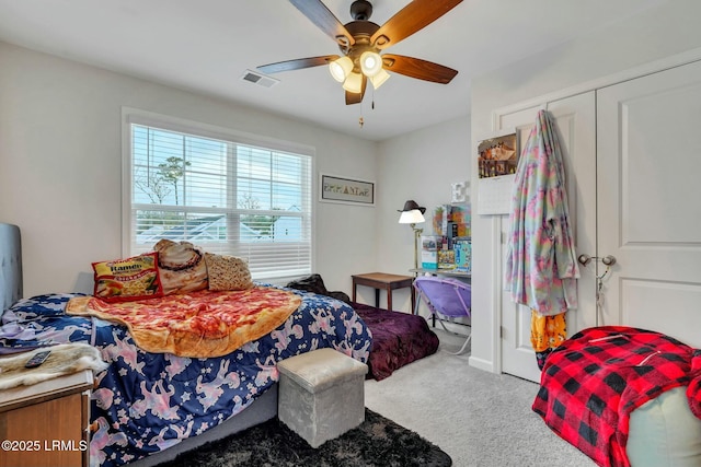 carpeted bedroom featuring ceiling fan and a closet