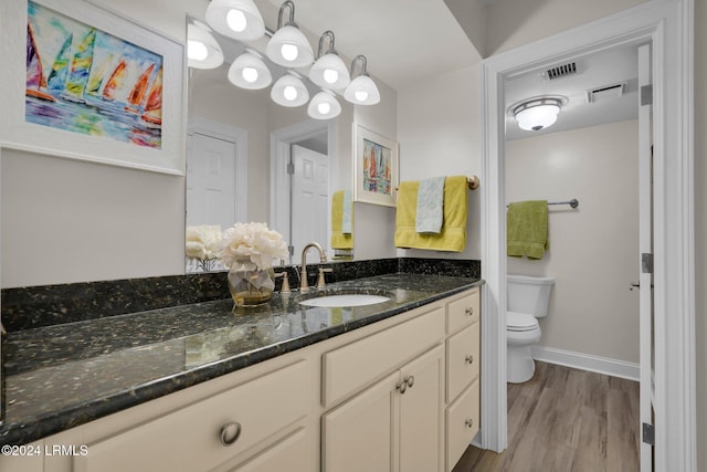 bathroom featuring vanity, wood-type flooring, and toilet