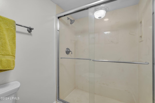 bathroom with toilet and a shower with shower door