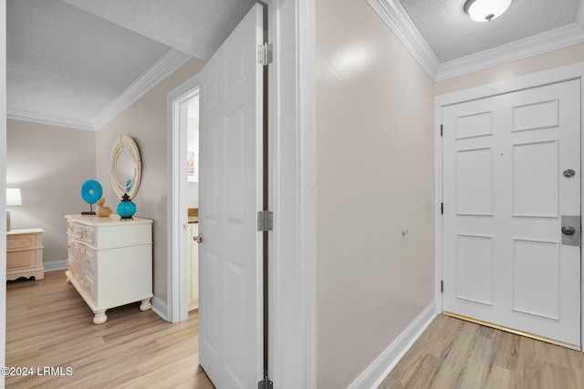 foyer entrance featuring crown molding, light hardwood / wood-style flooring, and a textured ceiling