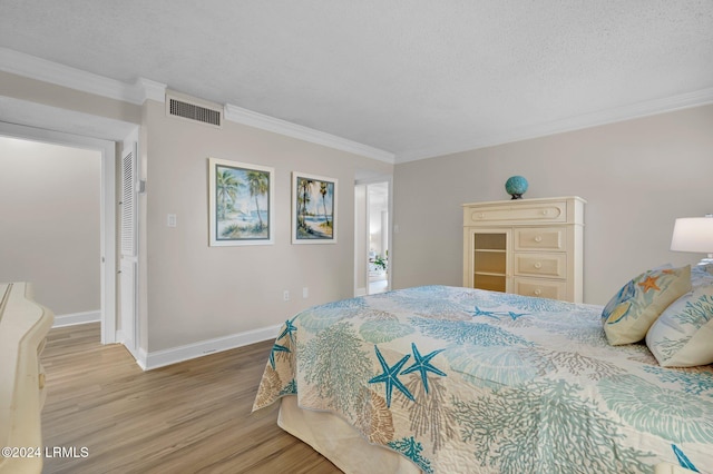 bedroom with hardwood / wood-style flooring, ornamental molding, a textured ceiling, and a closet