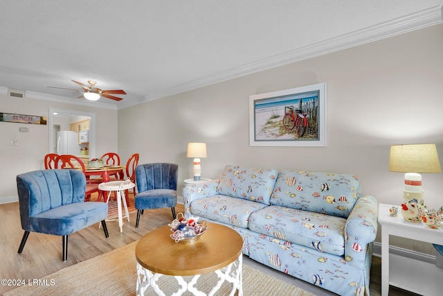 living room with ornamental molding, hardwood / wood-style floors, and ceiling fan