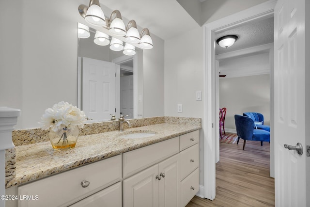 bathroom featuring wood-type flooring, vanity, and a textured ceiling