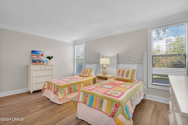 bedroom with multiple windows, ornamental molding, and light hardwood / wood-style floors