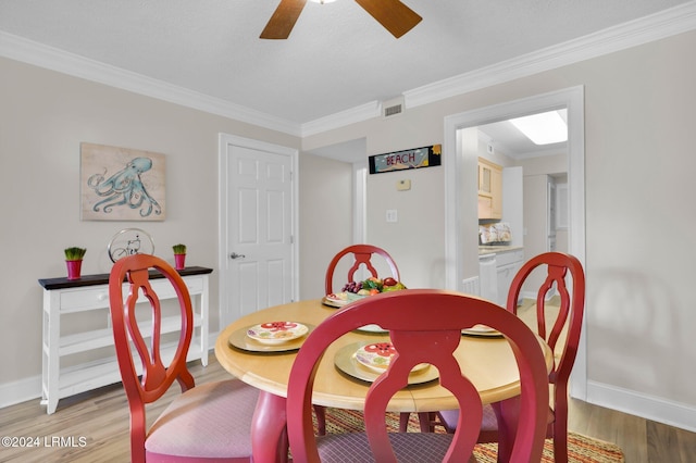 dining space with crown molding, ceiling fan, and wood-type flooring