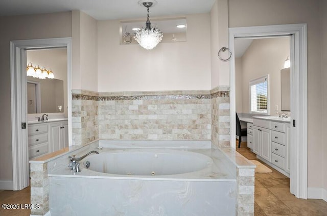 full bathroom featuring a garden tub, a chandelier, and vanity