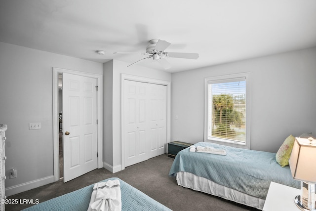 bedroom with a ceiling fan, baseboards, dark carpet, and a closet