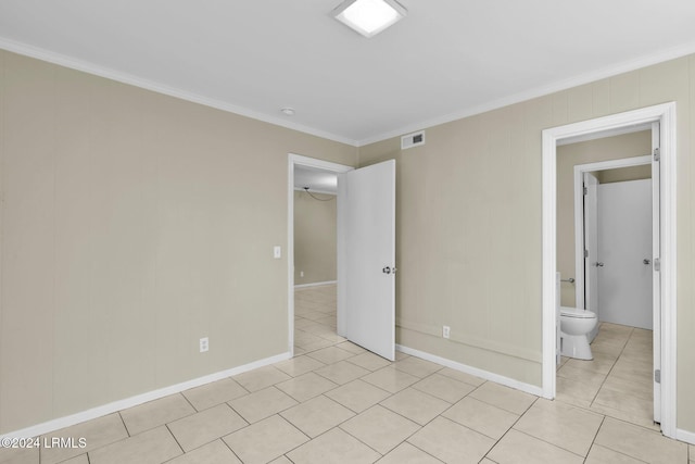 unfurnished bedroom with crown molding, ensuite bathroom, and light tile patterned floors