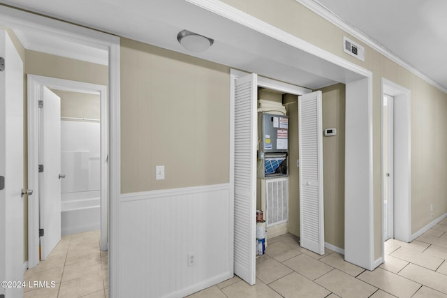 corridor featuring crown molding and light tile patterned flooring