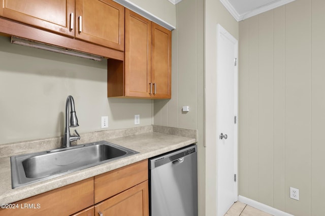 kitchen with light tile patterned flooring, wood walls, sink, stainless steel dishwasher, and crown molding