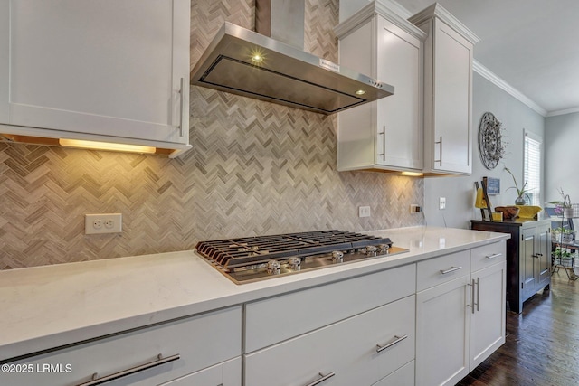 kitchen featuring white cabinetry, wall chimney exhaust hood, crown molding, and stainless steel gas cooktop