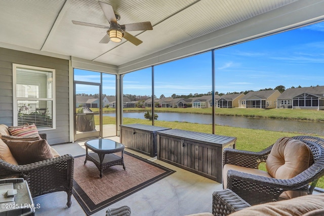 sunroom / solarium featuring a water view, a residential view, and ceiling fan