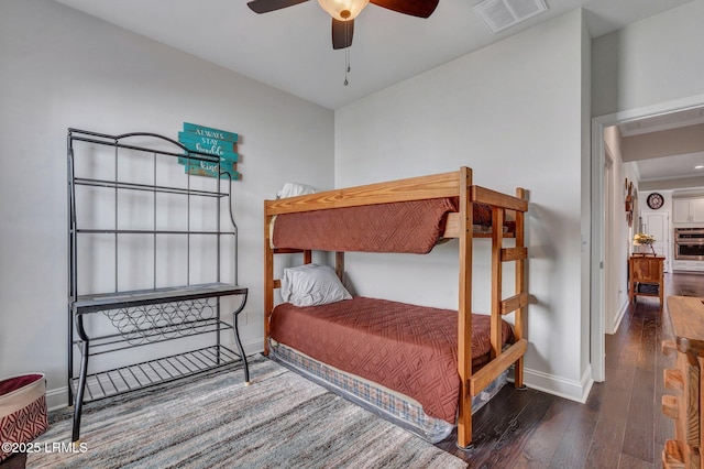 bedroom featuring hardwood / wood-style flooring, baseboards, visible vents, and ceiling fan