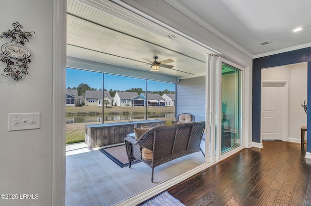 interior space with a residential view, visible vents, ceiling fan, and a water view