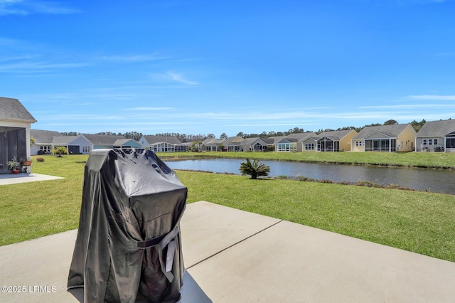 view of patio / terrace featuring a residential view, area for grilling, and a water view