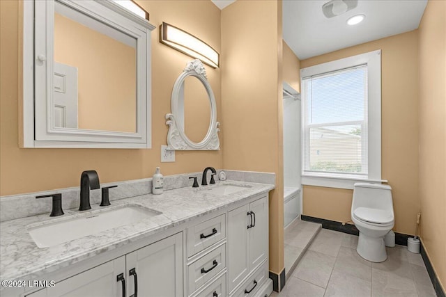 bathroom with a tub to relax in, vanity, toilet, and tile patterned flooring