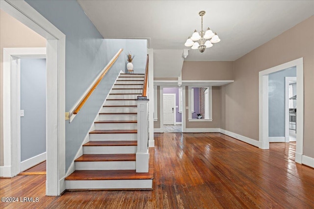 staircase with hardwood / wood-style flooring and a chandelier