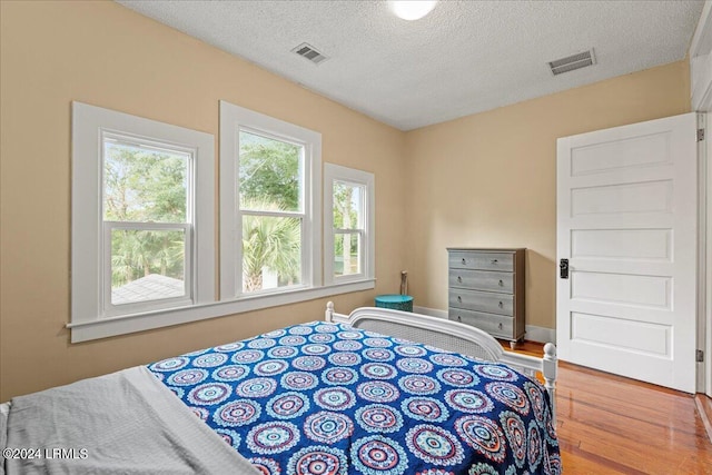 bedroom featuring hardwood / wood-style floors and a textured ceiling