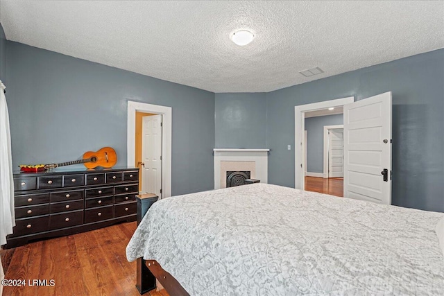 bedroom with dark wood-type flooring and a textured ceiling